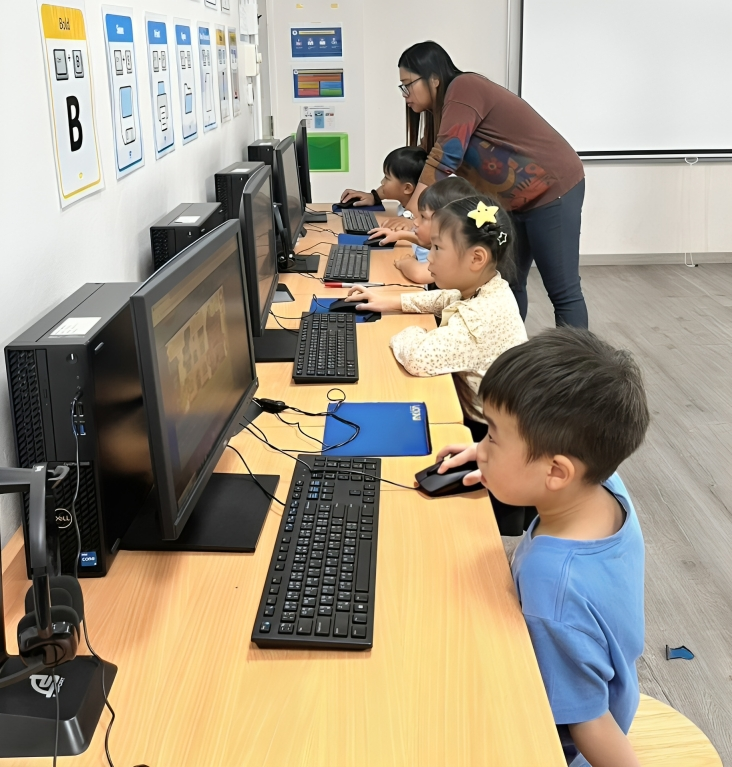 Young learners practice computer skills in the ICT lab.