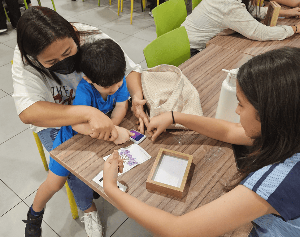 A parent helping her child in an art activity in the bonding session.