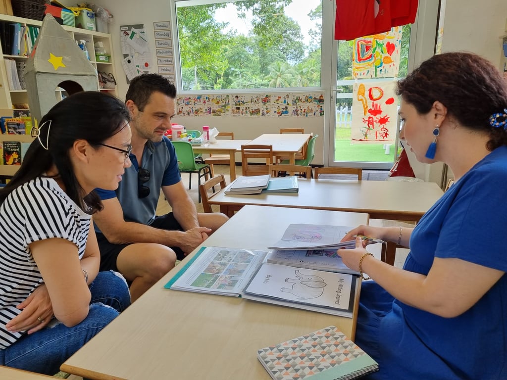 Parents and teachers discussing about child's progression in a parent-teacher conference. 