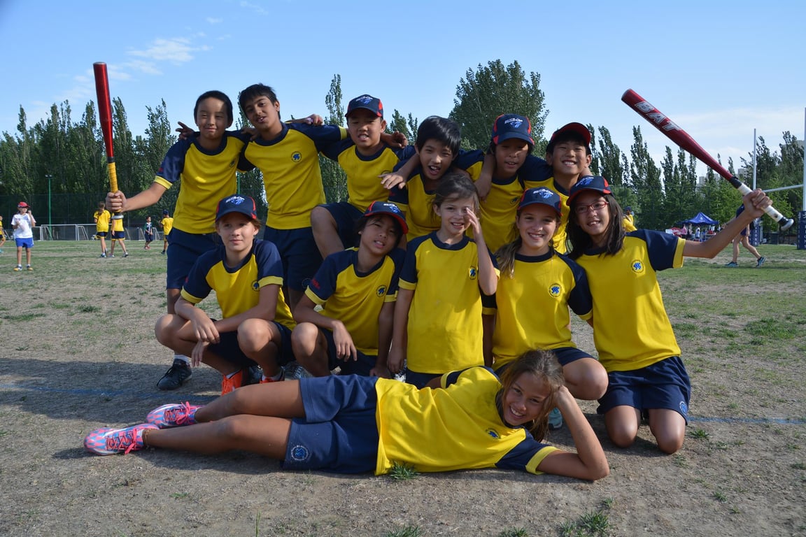 Students in team uniforms pose after a school match.
