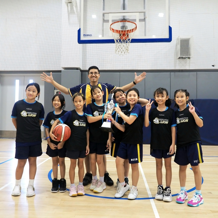 BCIS girls' basketball team celebrates their tournament win.