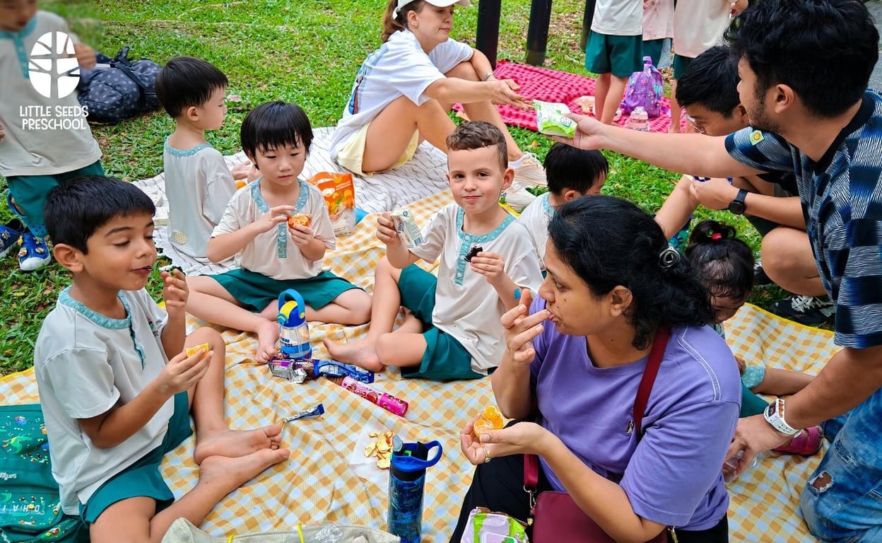 Children and parents enjoying a cosy picnic together at Admiralty Park after a day of play and exploration.