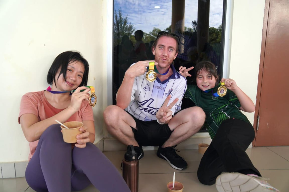 Parents posing with their child after the Merdeka Run.