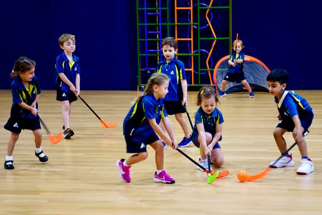 Primary school students competing in a hockey game during the Early Years World Cup, an inter-class competition