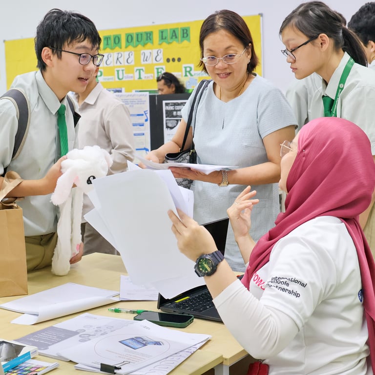 Parents and students engaging with teachers at a school event.