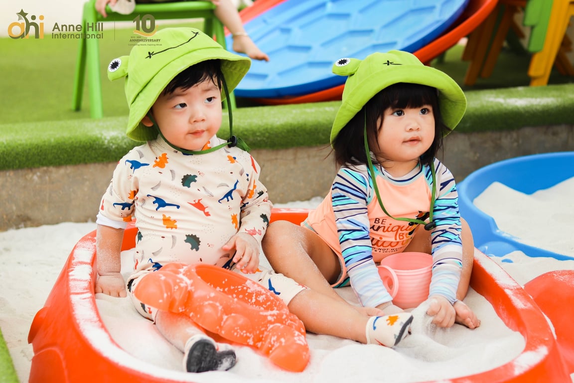 Playgroup students exploring textures during sand play activity.