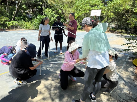 Parents collaborating during a team-building challenge at Shek Pik.