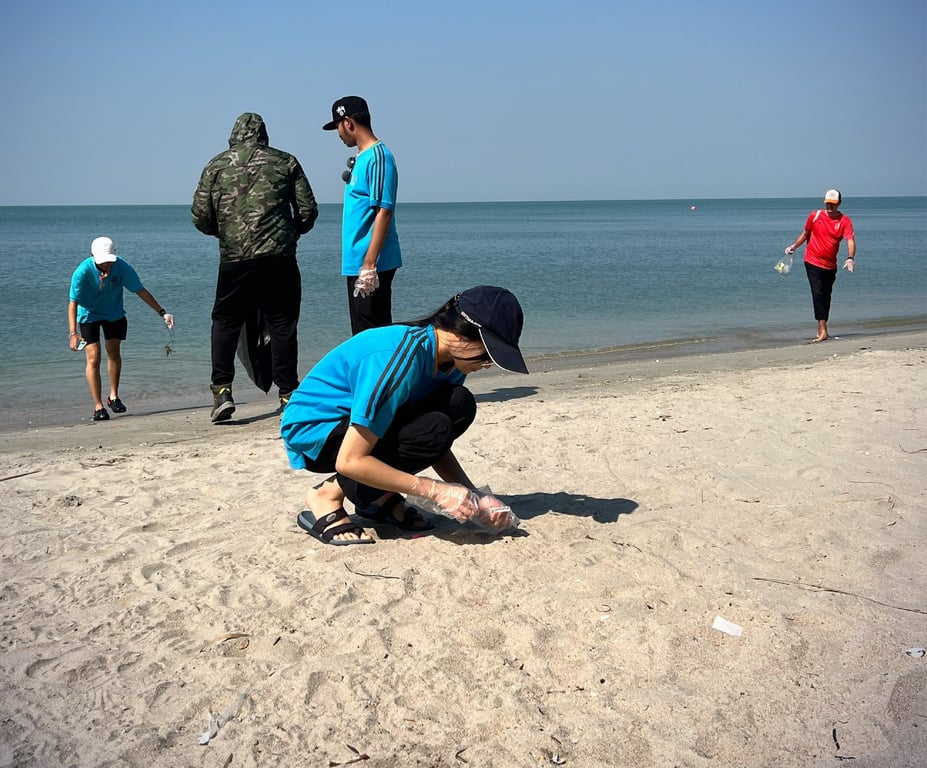 Students collect plastic during a beach clean-up activity.