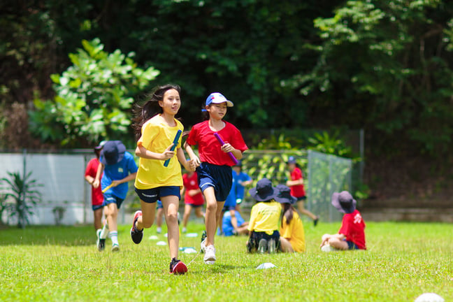 Students take part in a relay race during outdoor PE lessons, promoting teamwork, fitness, and fun.