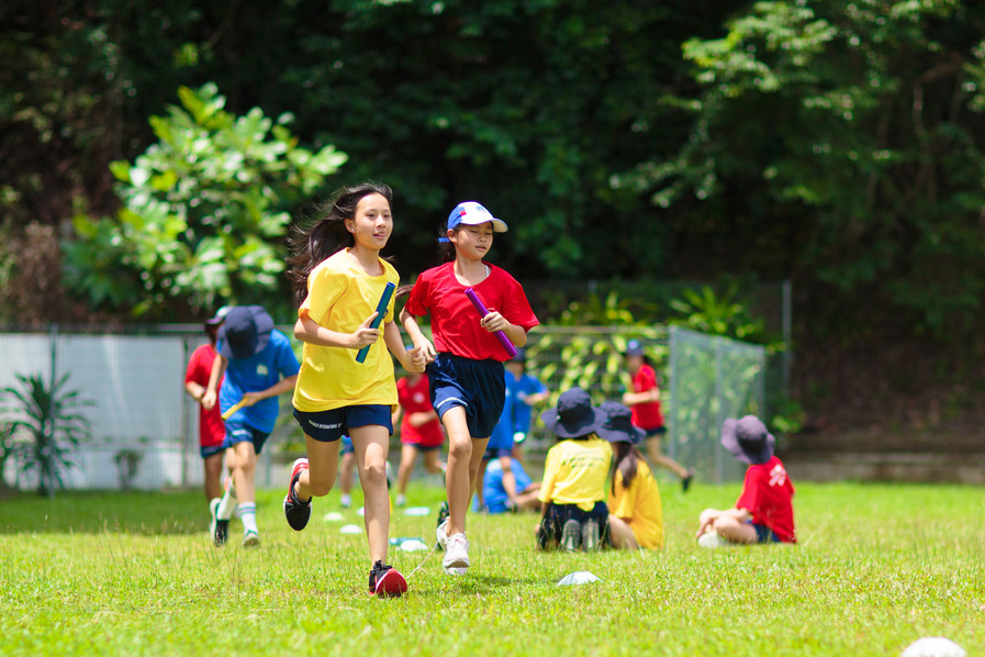 Students take part in a relay race during outdoor PE lessons, promoting teamwork, fitness, and fun.