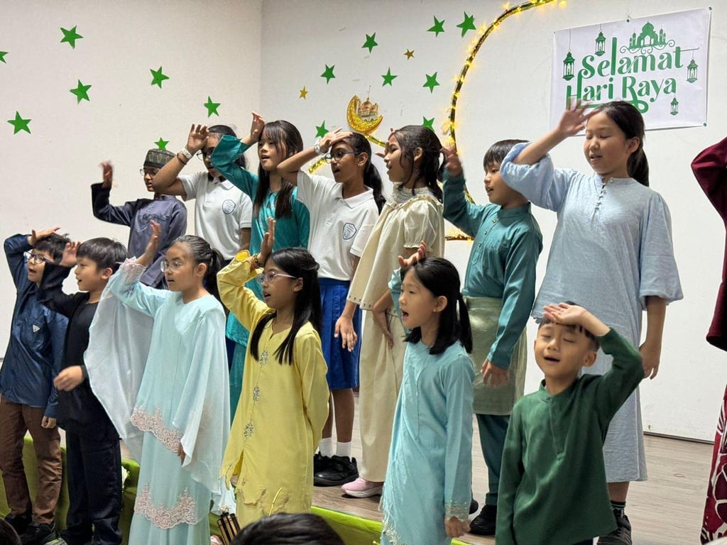 Students perform a festive song during MES’s Hari Raya celebration, dressed in traditional attire to honour the occasion.