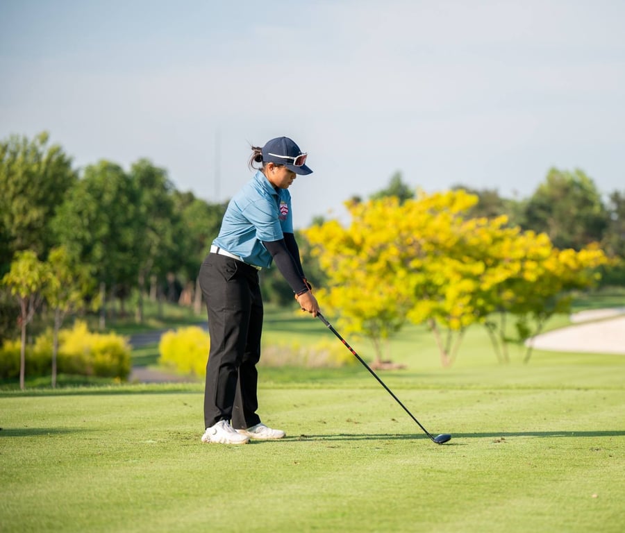 Young golfer practices on the course.