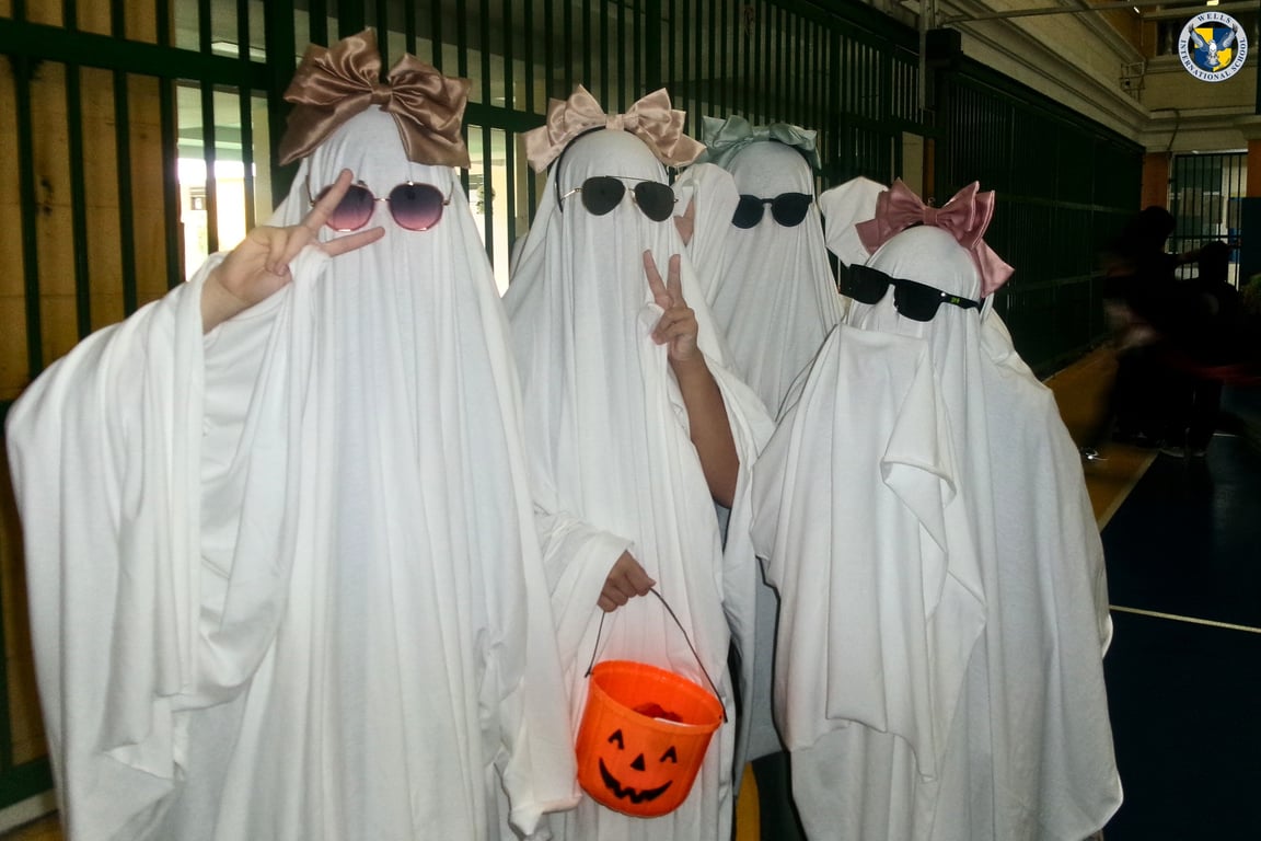 Group of students in ghost costumes with sunglasses.