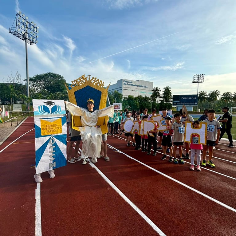 A student is carried in a creatively designed throne during Sports Day opening ceremonies, celebrating house pride and creative performance.