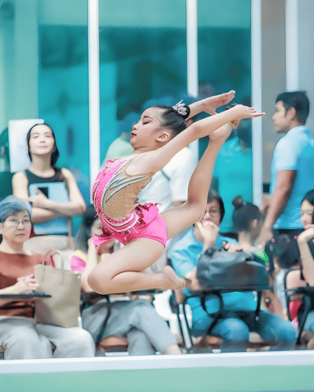 Student performs rhythmic gymnastics in front of an audience.