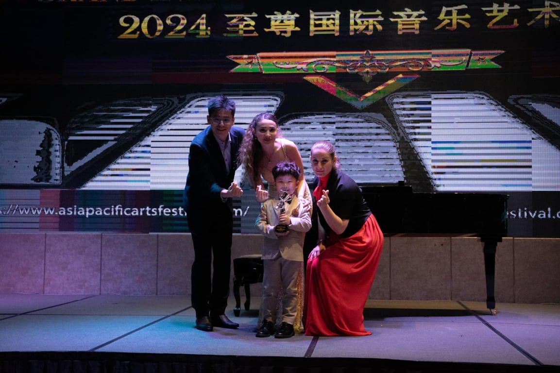 A young student is awarded on stage at the Asia Pacific Arts Festival, representing the school in international piano performance.