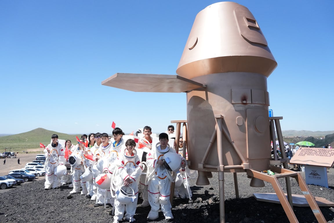 Students in astronaut suits participating in a space-themed field activity.