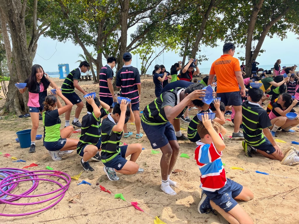 Collaboration in action — team-building activities on the beach inspire problem-solving, leadership, and friendship.