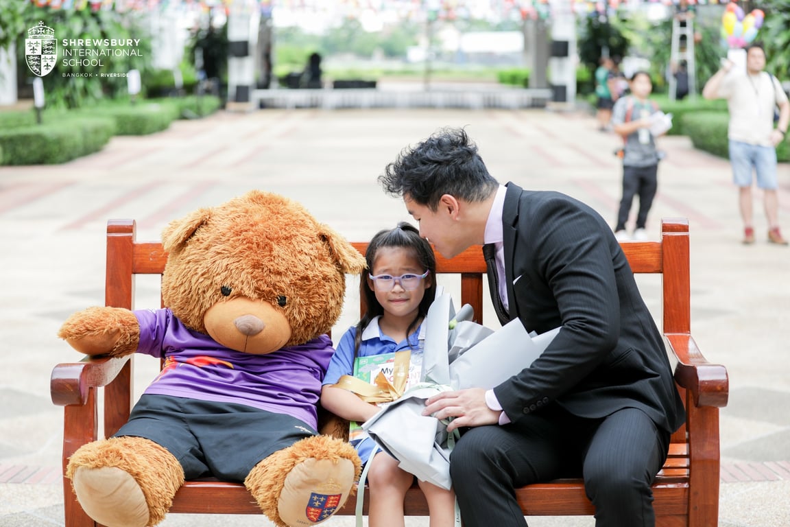 Post-graduation moment with parent and school teddy.