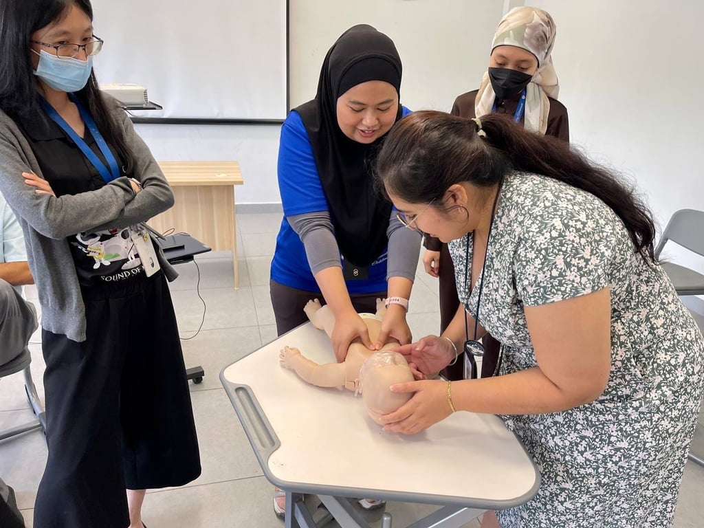 Teachers participate in practical CPR training, reinforcing the school’s commitment to student safety and staff preparedness.