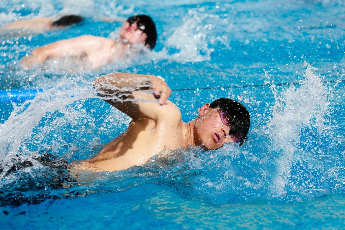Students show focus and determination in the pool, building strength and technique during swimming practice.