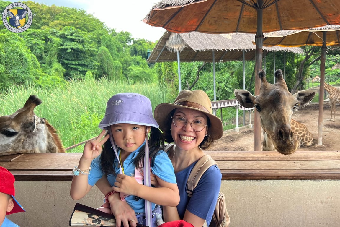 Student and teacher posing with giraffes at Safari World.