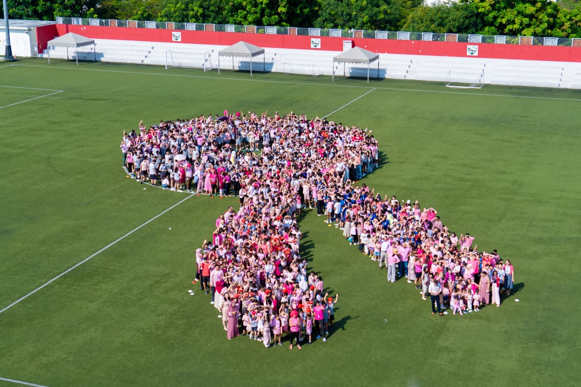 students, teachers, and staff came together to create a giant pink ribbon on the field for the Think Pink initiative, which focuses on supporting women with breast cancer