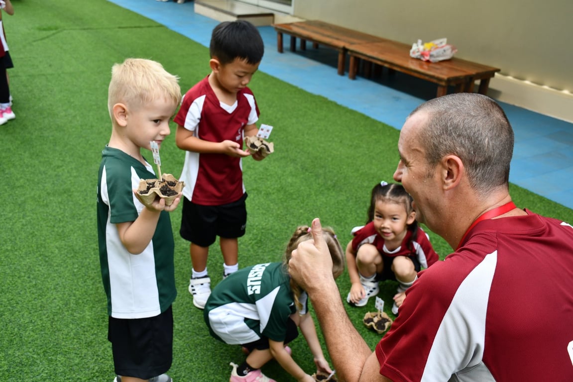 Kindergarten students learning to plant seeds during an outdoor activity.