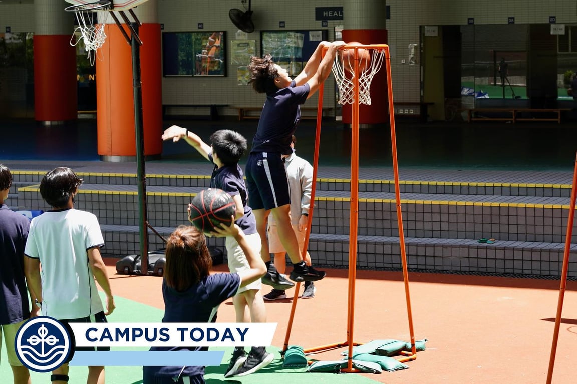 Students playing basketball together during outdoor break on the school podium.
