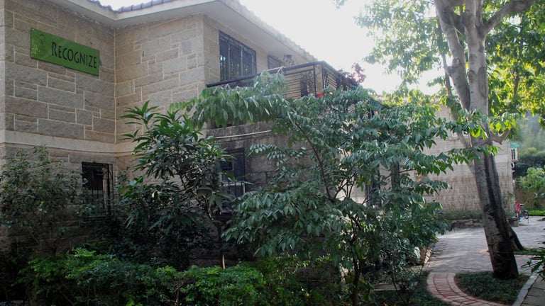 Recognise International Academy campus building surrounded by greenery.