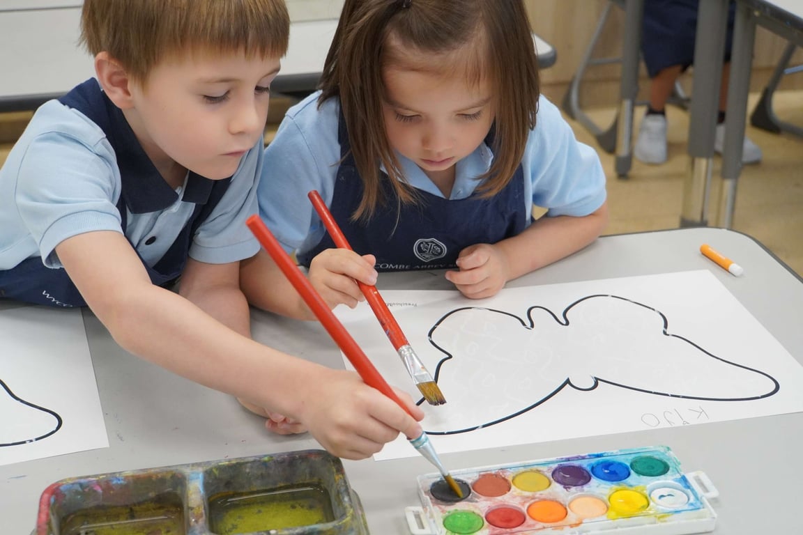 Year 1 students painting butterfly outlines with watercolours in art class.