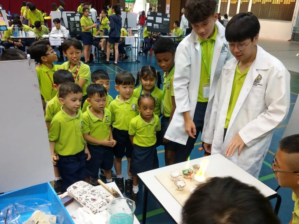 Primary students observing a science experiment demonstration at the school fair