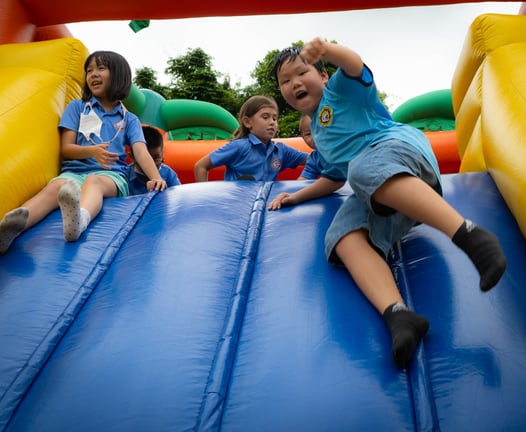 Students enjoying an inflatable slide during the back-to-school event.