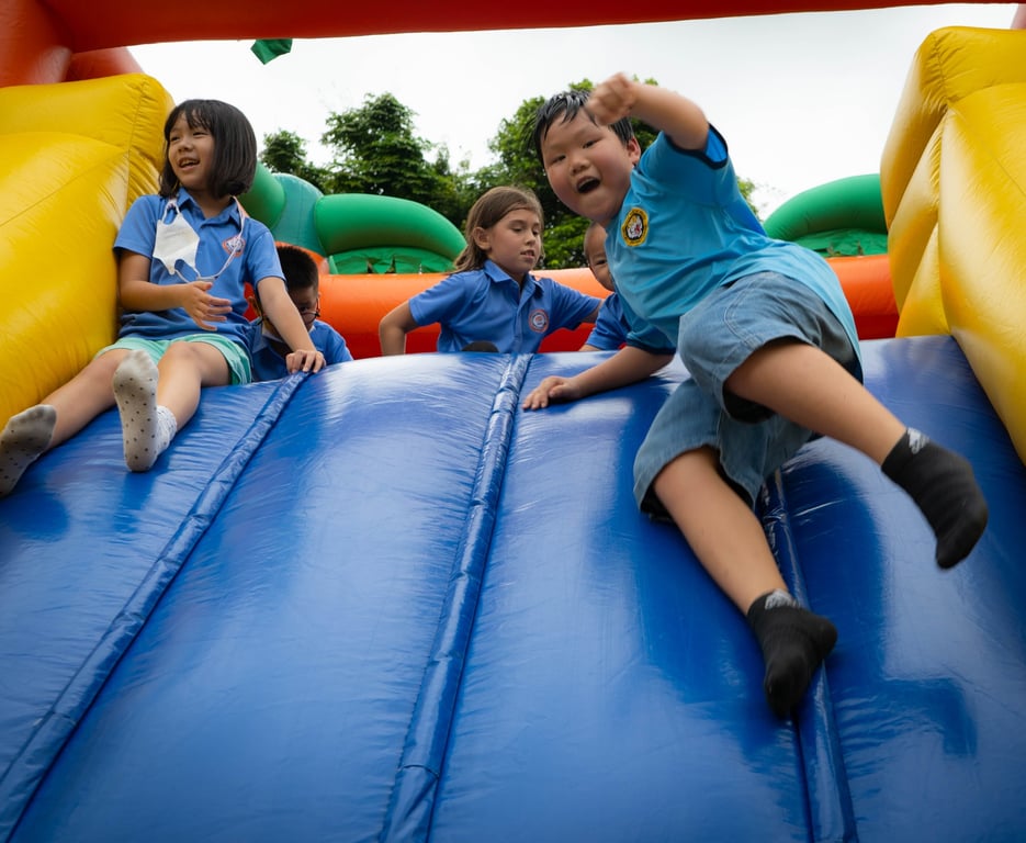 Students enjoying an inflatable slide during the back-to-school event.