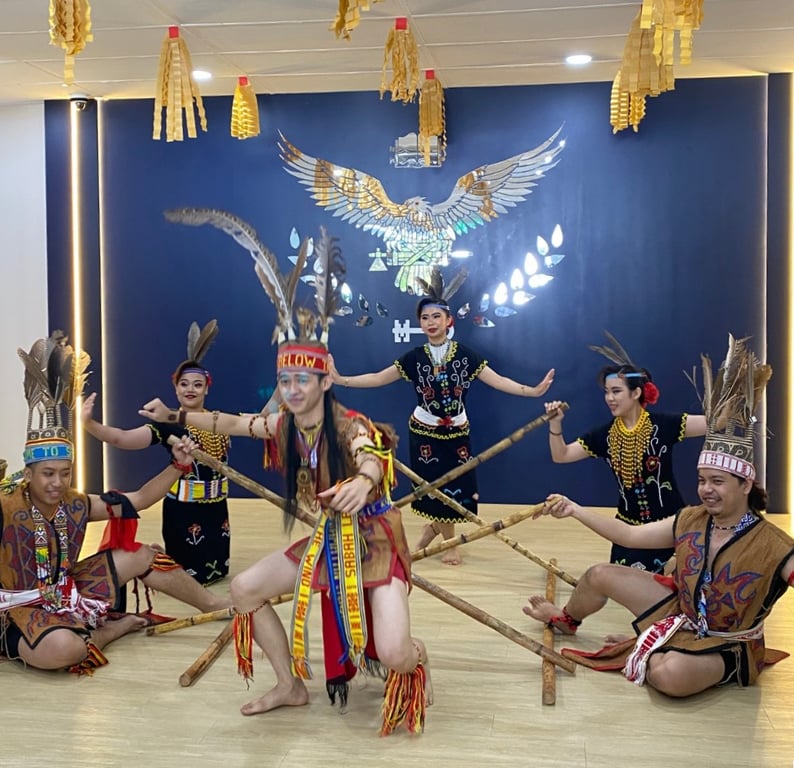 A traditional Sabahan bamboo dance in full costume, celebrating local heritage during a school cultural event.