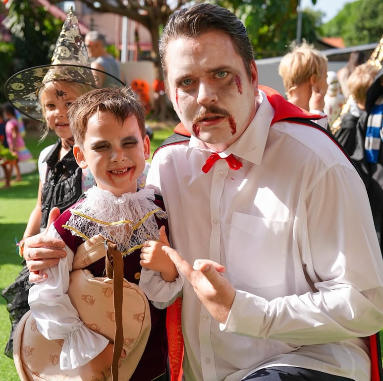 Teacher and student dressed in vampire costumes for Halloween event.