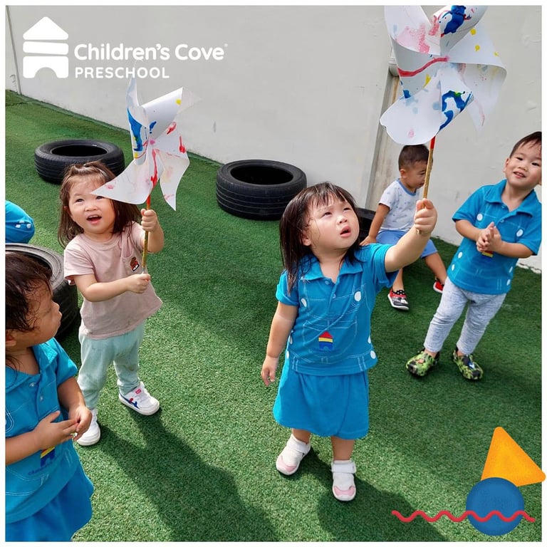 Children using pin wheels outside to learn about wind.