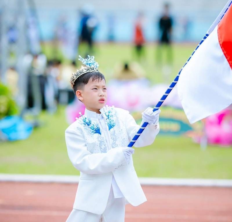 Parade opening with a student flag bearer.