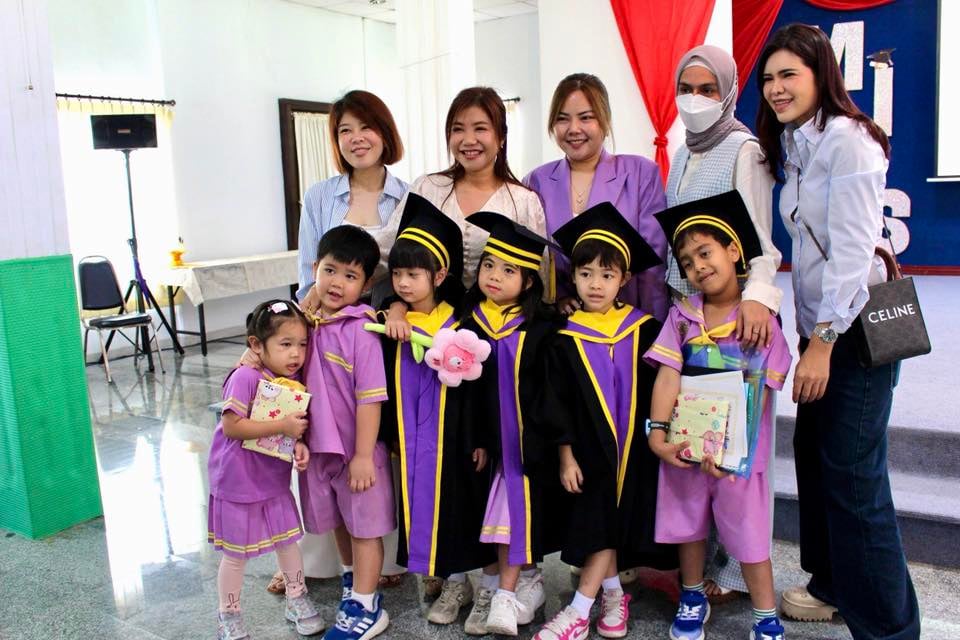 Parents posing with kids during the graduation ceremony.