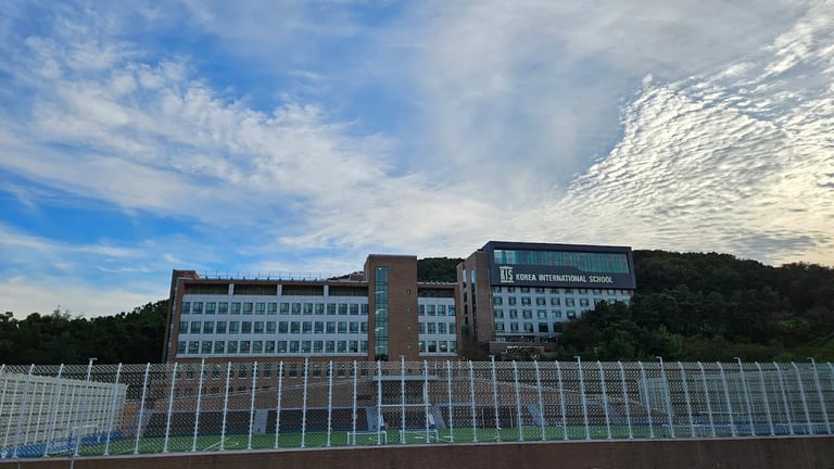Wide view of Korea International School Pangyo campus under a blue sky.