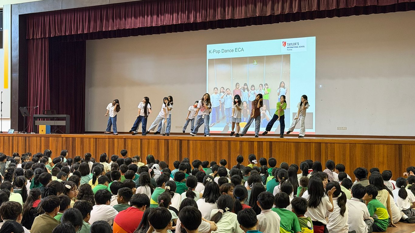 Students performing a K-Pop dance during assembly.