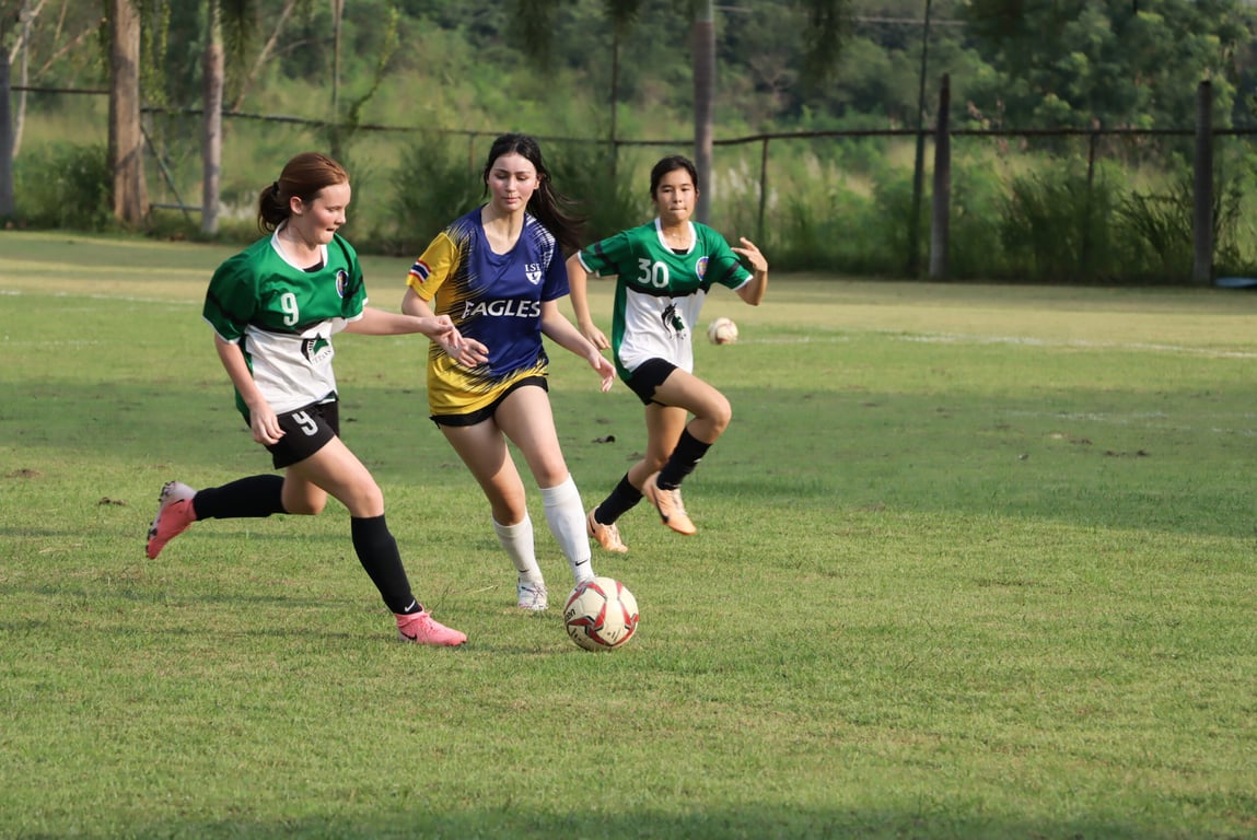 Mid-match movement as three players chase the ball.