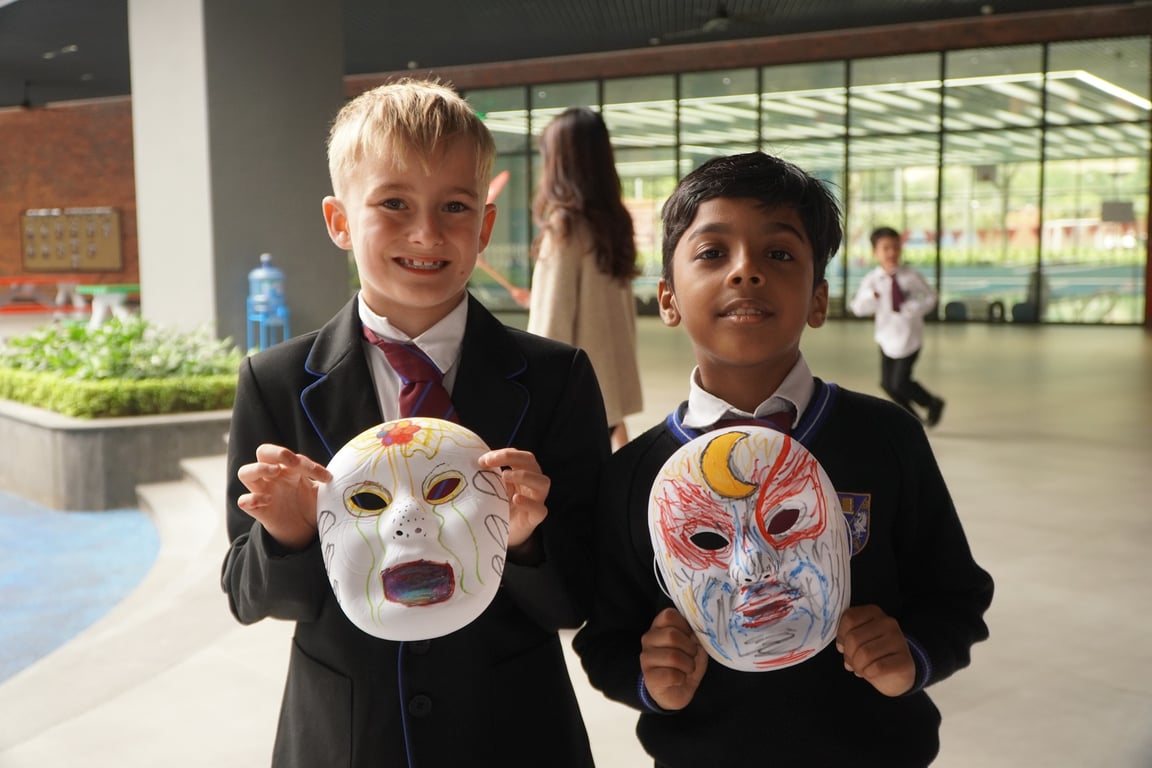 Students displaying their decorated masks during a cultural art activity.