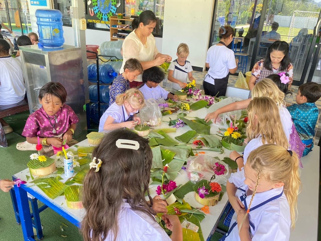 Students making krathongs from leaves and flowers for the festival.