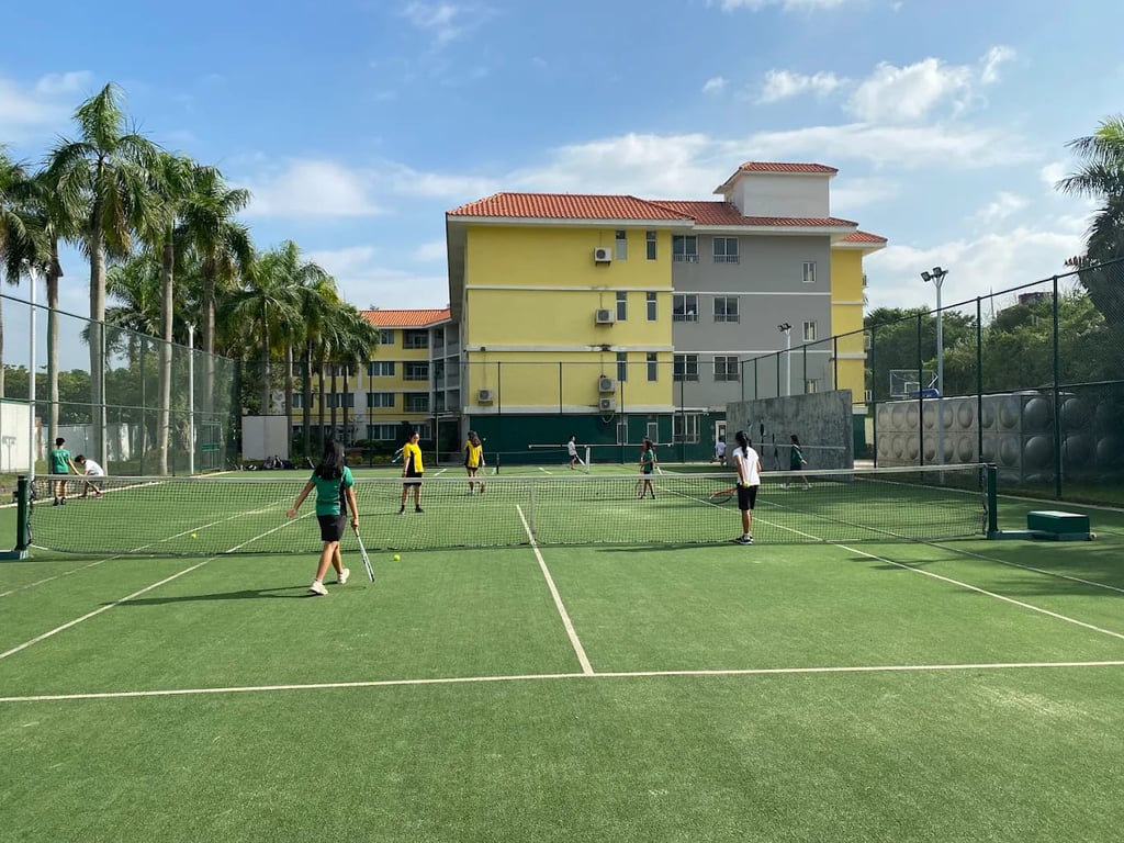 Students practicing their tennis skills on the outdoor courts at Zengcheng campus.