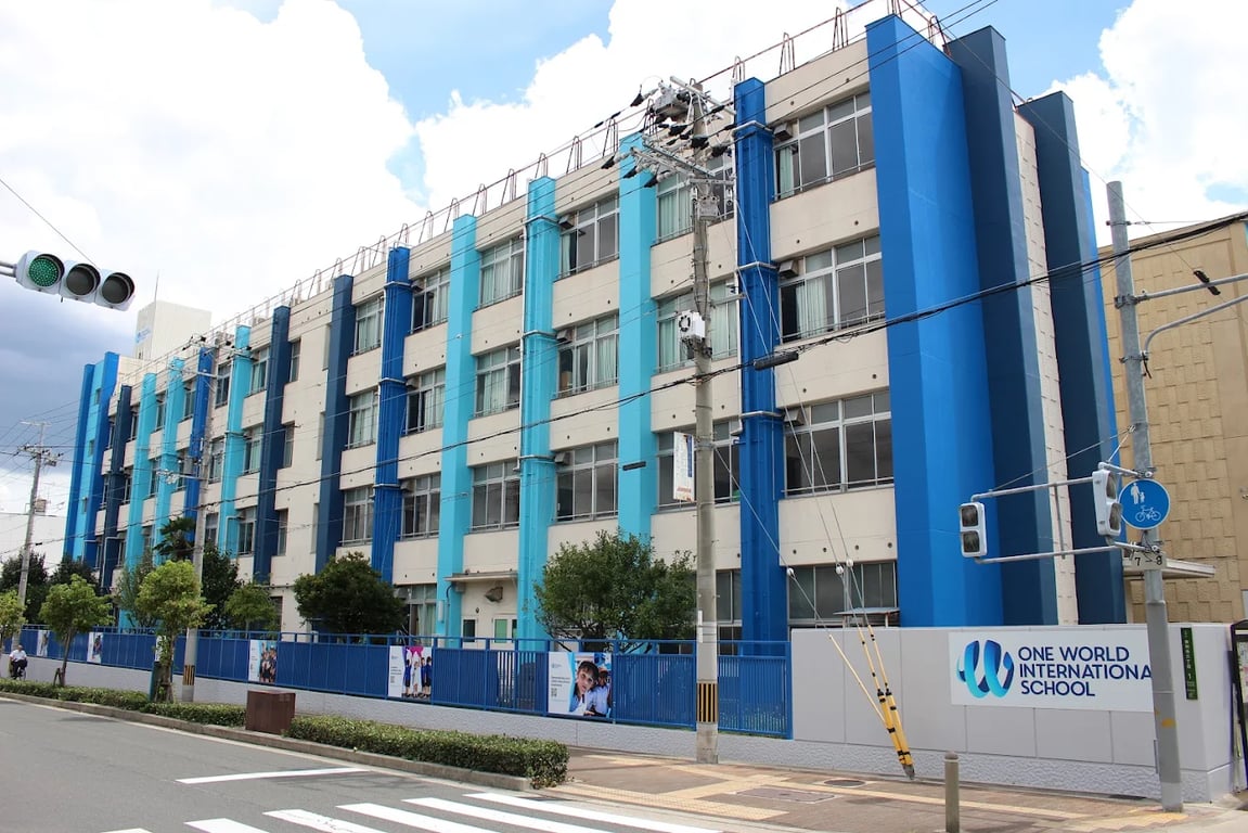 The vibrant blue facade of the One World International School Osaka campus building.