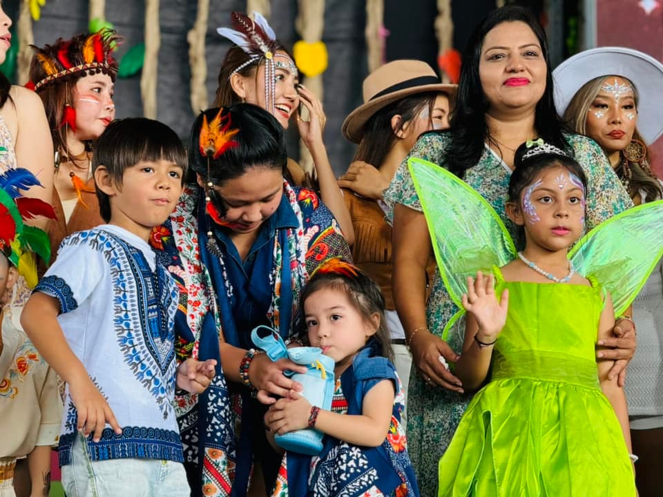 Students and parents dressed in Bohemian-themed outfits for Mother's Day celebration.