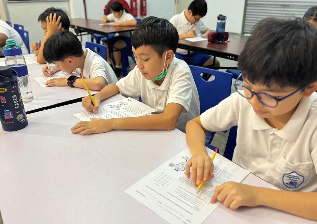 Students focused during a written assessment session, demonstrating their learning and preparation across core subjects.