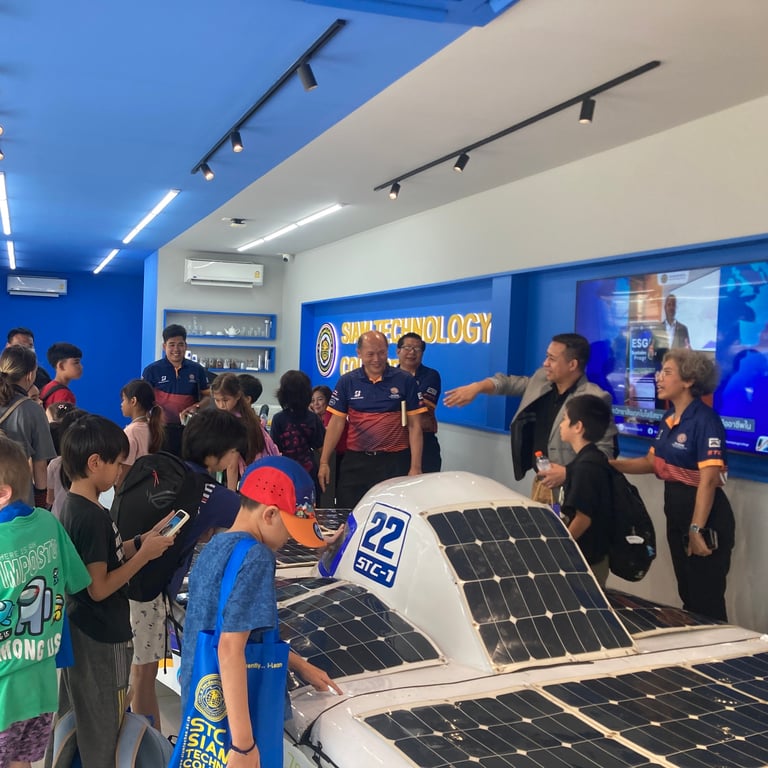 Students exploring solar car models during a field trip to Siam Technology College.