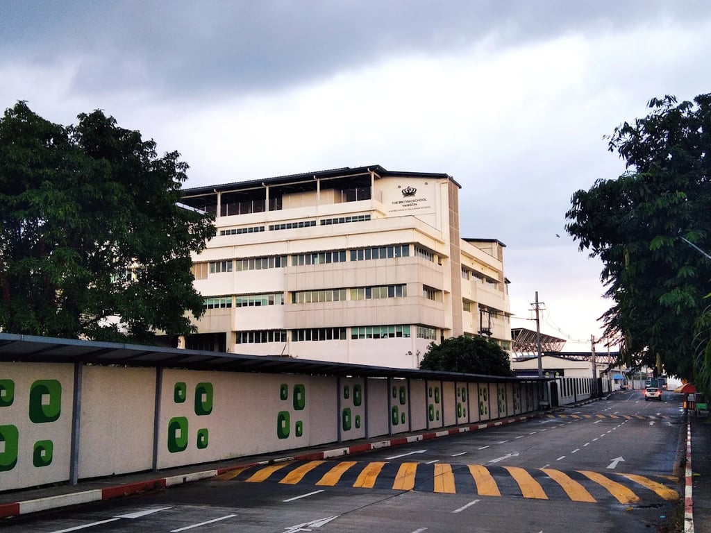 An exterior view of the multi-story school facility and the adjacent campus road.